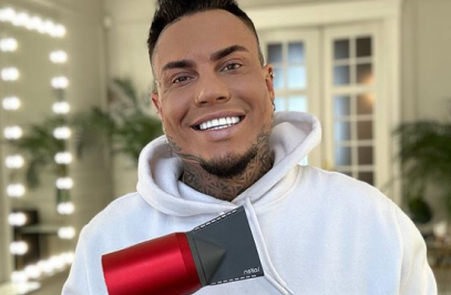 усмихнат мъж, който държи сешоар